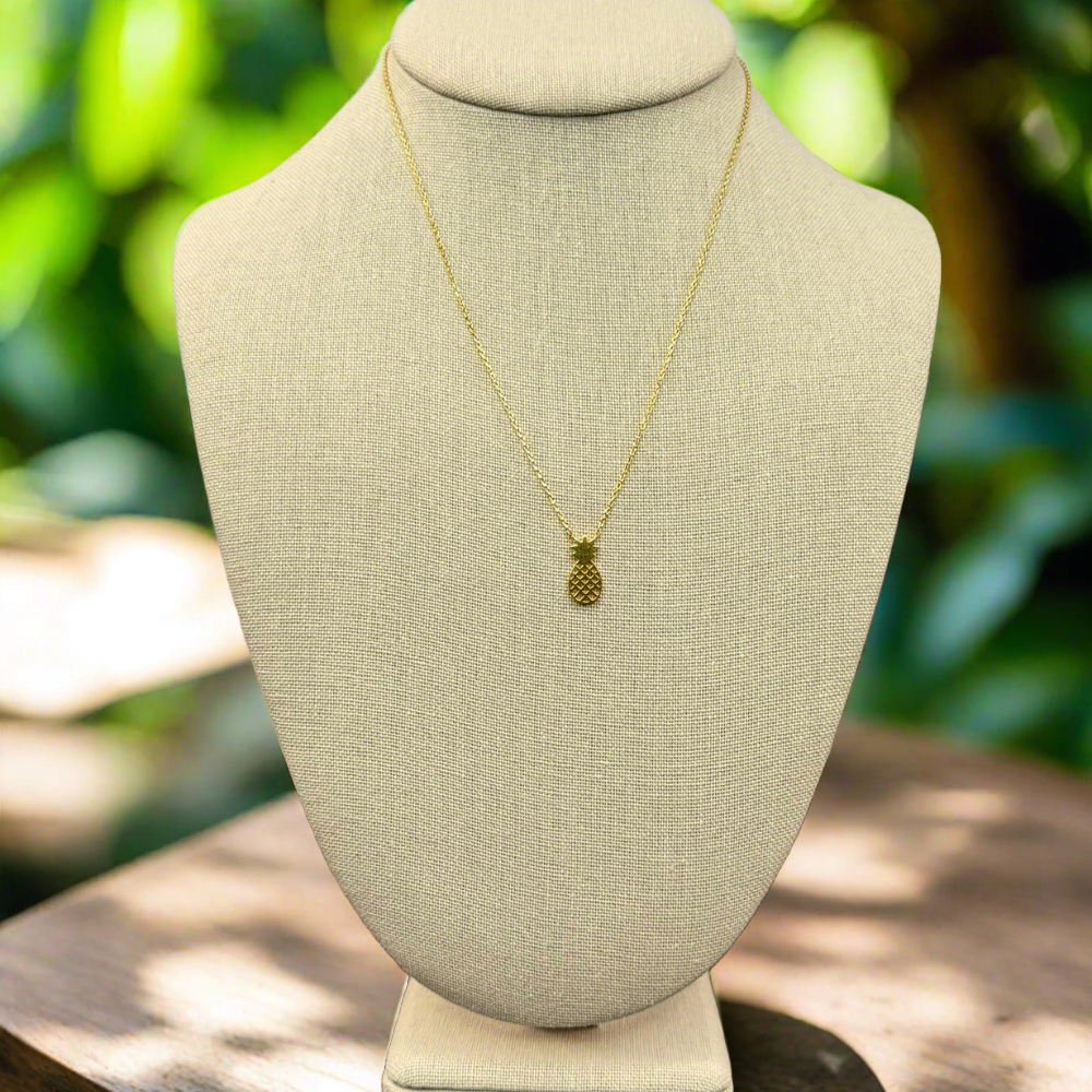 pineapple pendant necklace 18k gold dipped necklace is perfect jewelry accessory for beach lovers on linen jewelry display with tropical setting