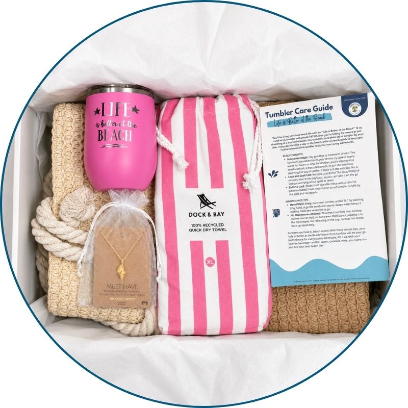 Pink beach lover gift set in a gift box with straw beach bag, pink striped towel, pink tumbler, gold-dipped conch shell necklace and bonus cards.