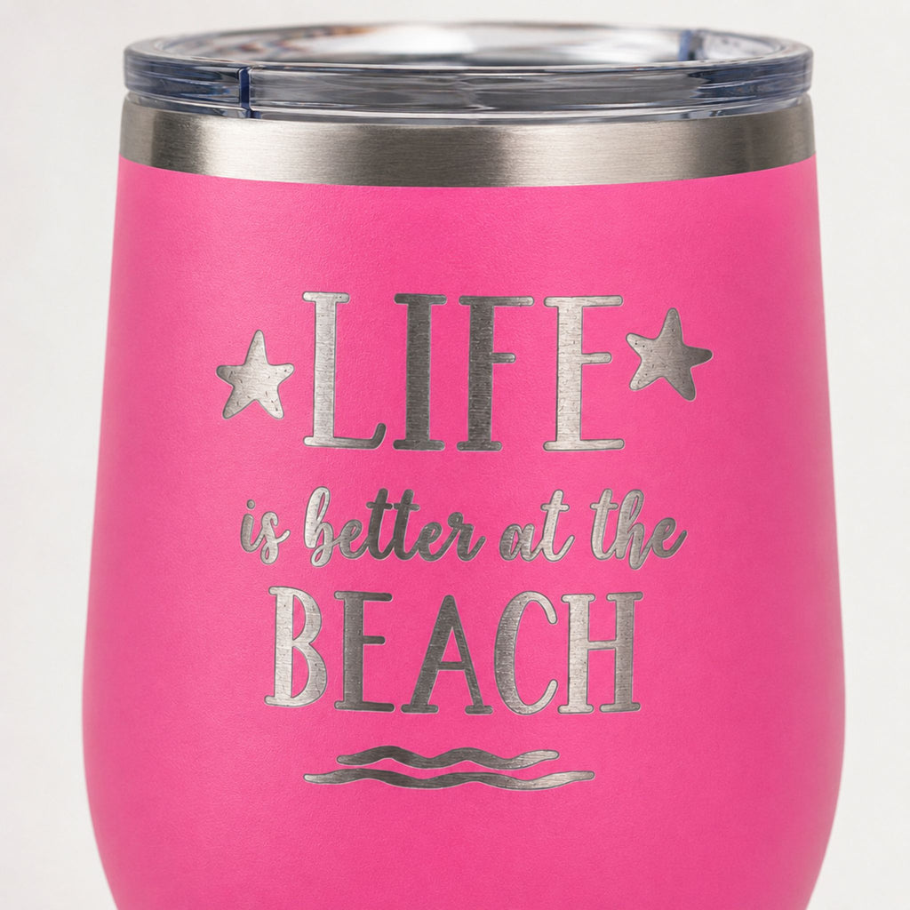 Close-up of pink beach tumbler with Life is Better at the Beach design