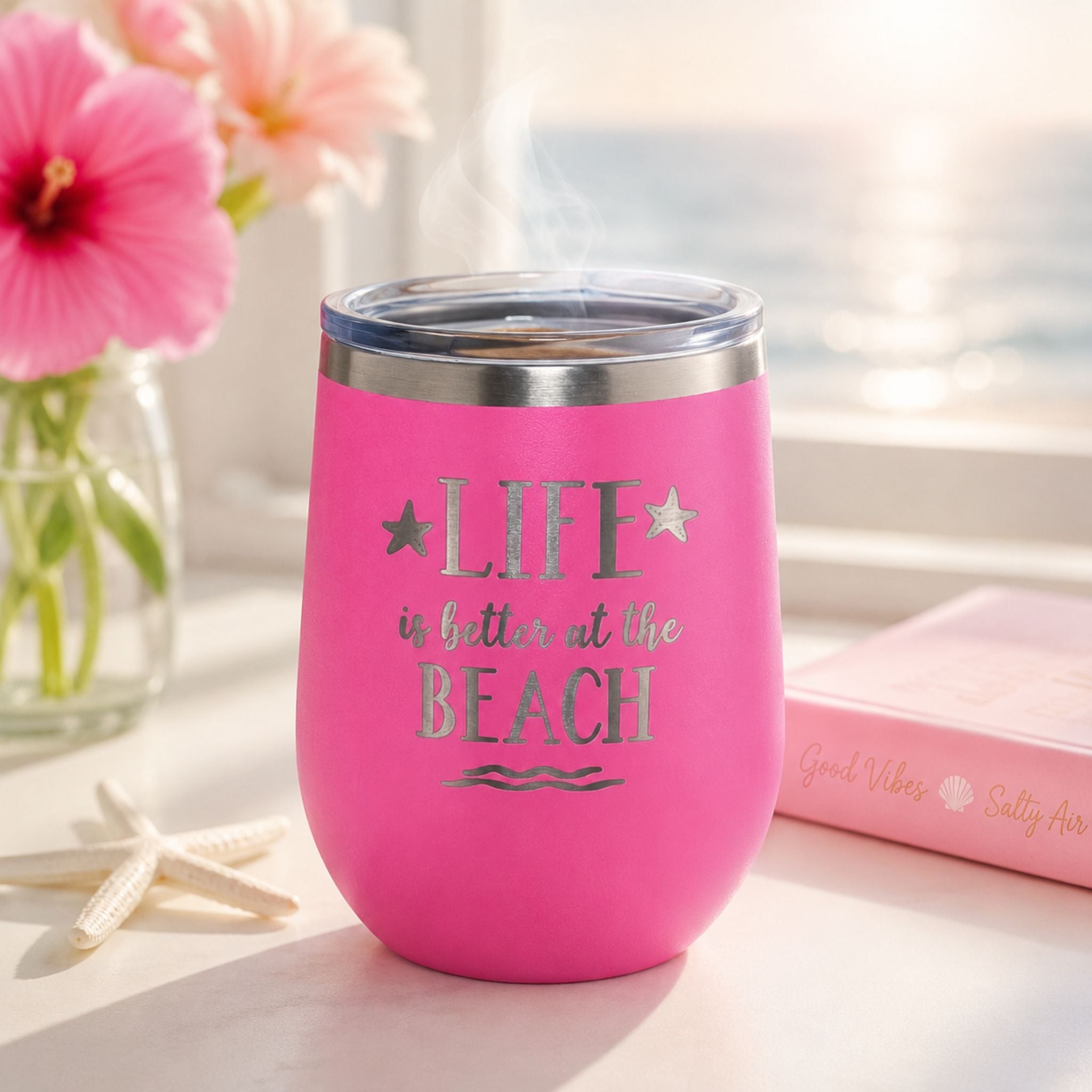 Pink insulated wine tumbler for hot coffee in a bright coastal morning setting