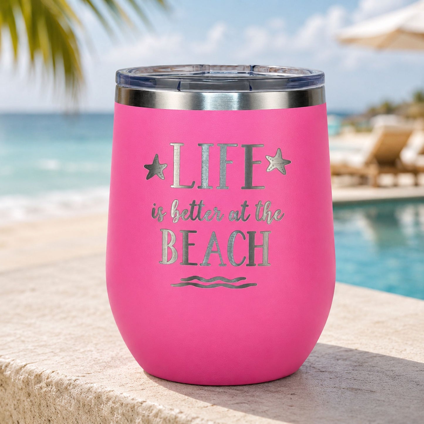 Pink Life Is Better at the Beach tumbler in a relaxing resort beach setting with ocean and pool view.