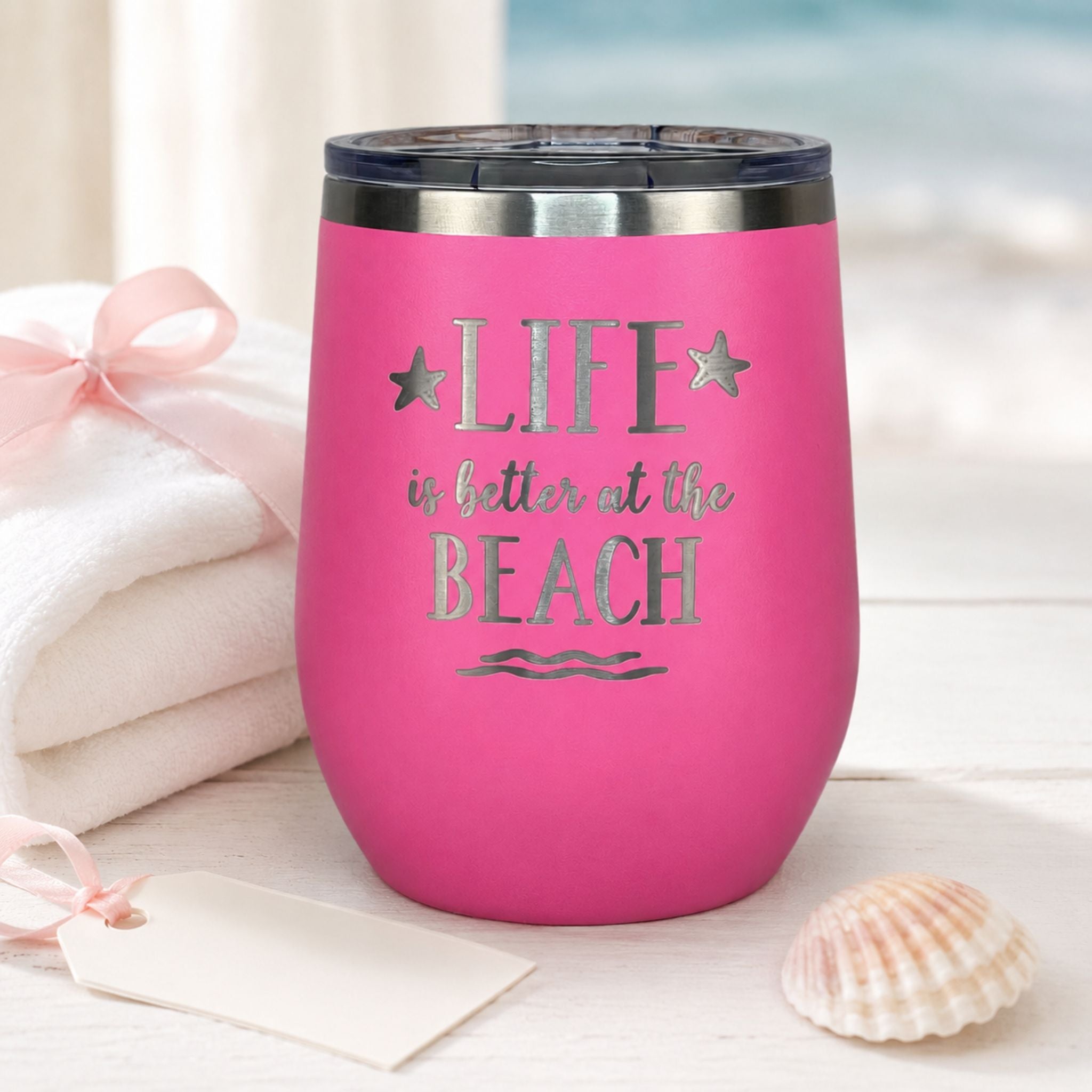 Pink stainless steel wine tumbler styled as a thoughtful beach lover gift