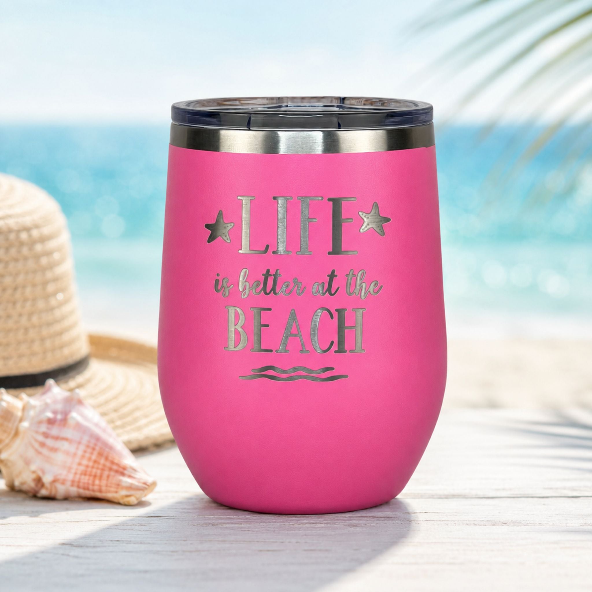Pink wine tumbler with lid styled for beach days and coastal sipping