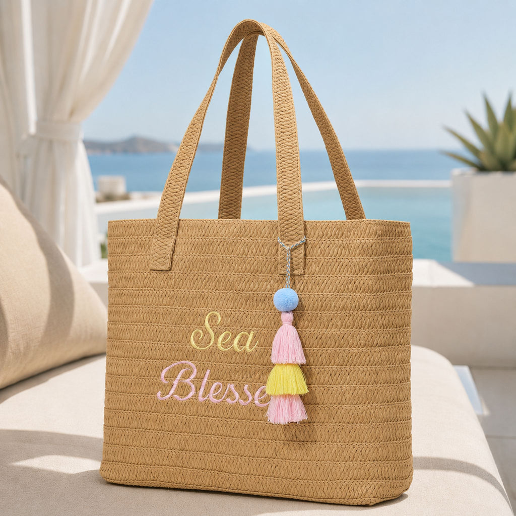 Sea Blessed raffia tote bag on a cream cabana seat overlooking the ocean