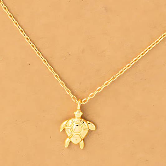 Close-up image of the 18k gold-dipped sea turtle pendant necklace, revealing its elegant design and textured details