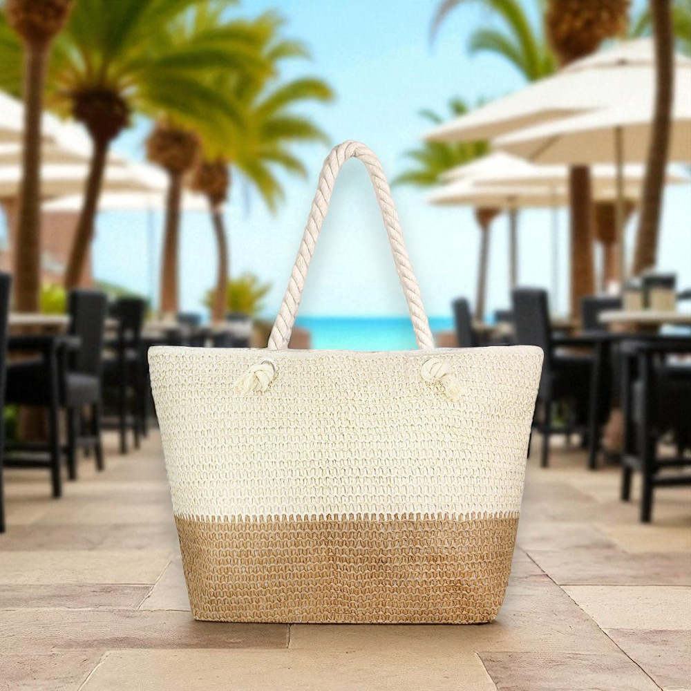 oversized straw beach tote bag in a beach cafe setting with black iron tables and umbrellas
