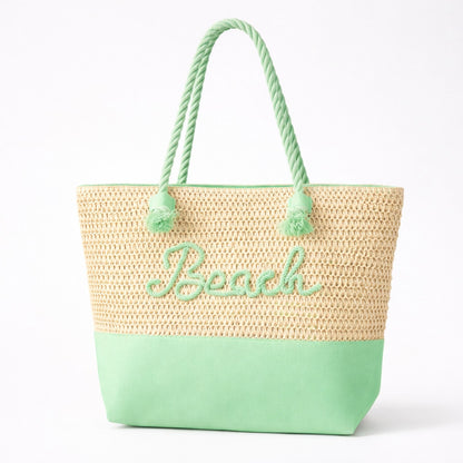 Mint green straw beach tote bag with zipper, rope handles, and raised “Beach” lettering on white background