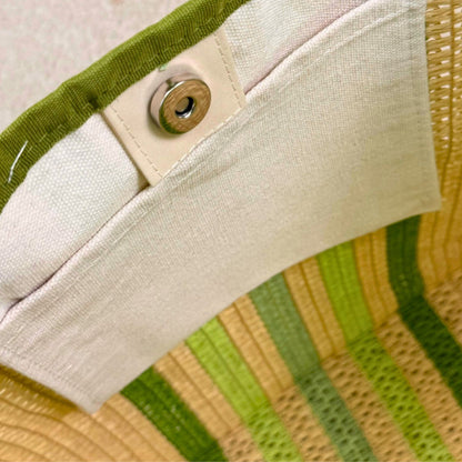 close-up of inside pocket with magnetic closure of a green striped straw beach bag tote