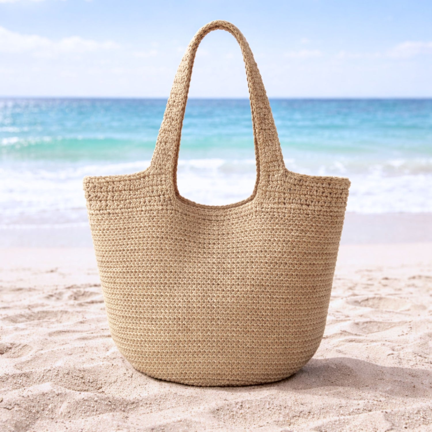 Tan straw hobo slouch tote bag on the beach.