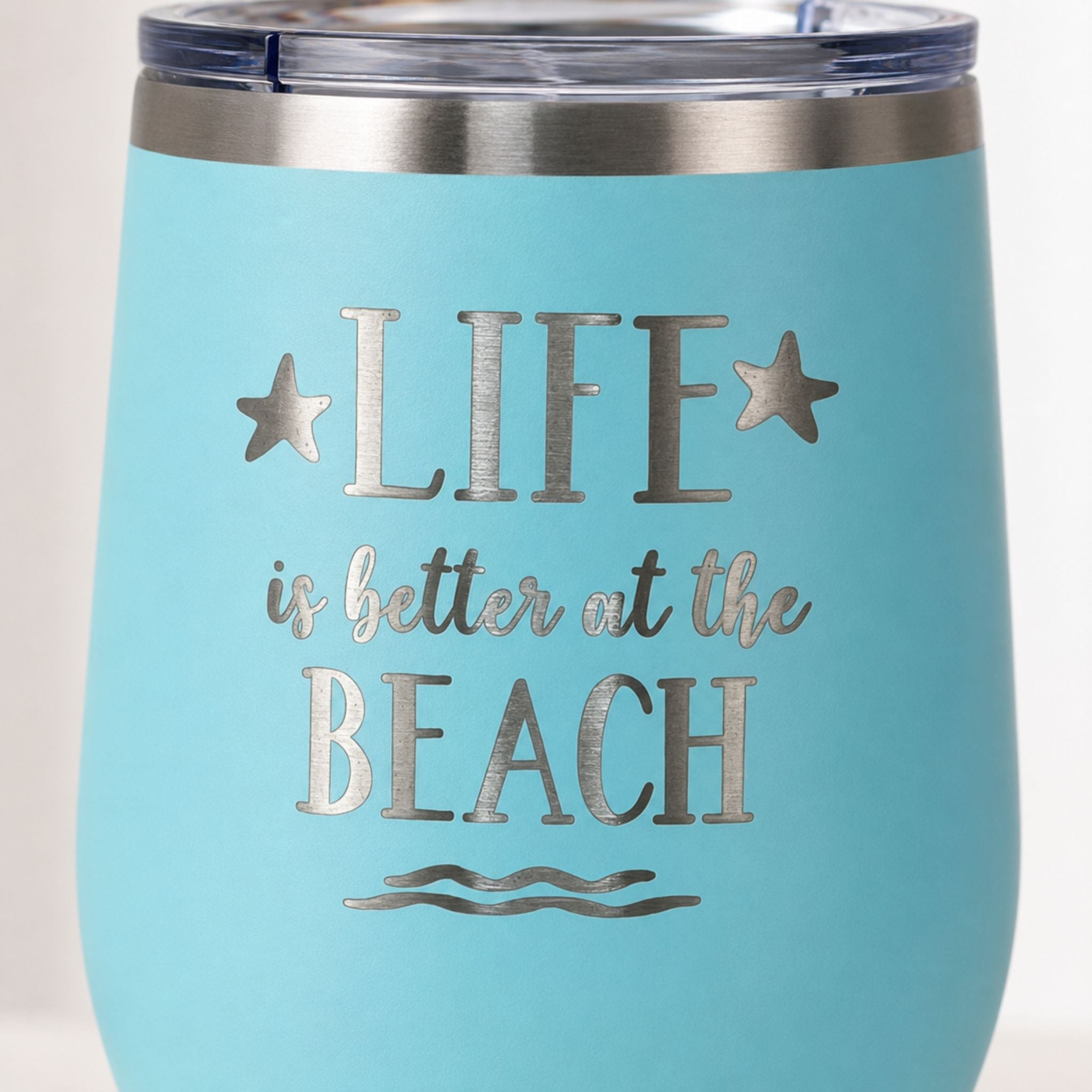 Close-up of teal Life is Better at the Beach insulated wine tumbler with lid