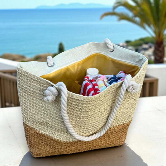 Straw tote beach bags packed with towels and beach essentials on a resort balcony overlooking the ocean, styled as a women's beach bag for vacation.