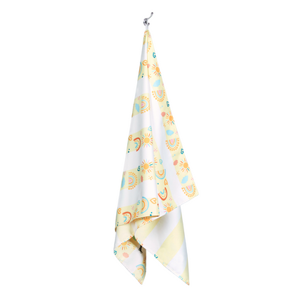 pastel, yellow striped rainbow pattern quick dry sand free kids beach towel hanging on a hook to dry